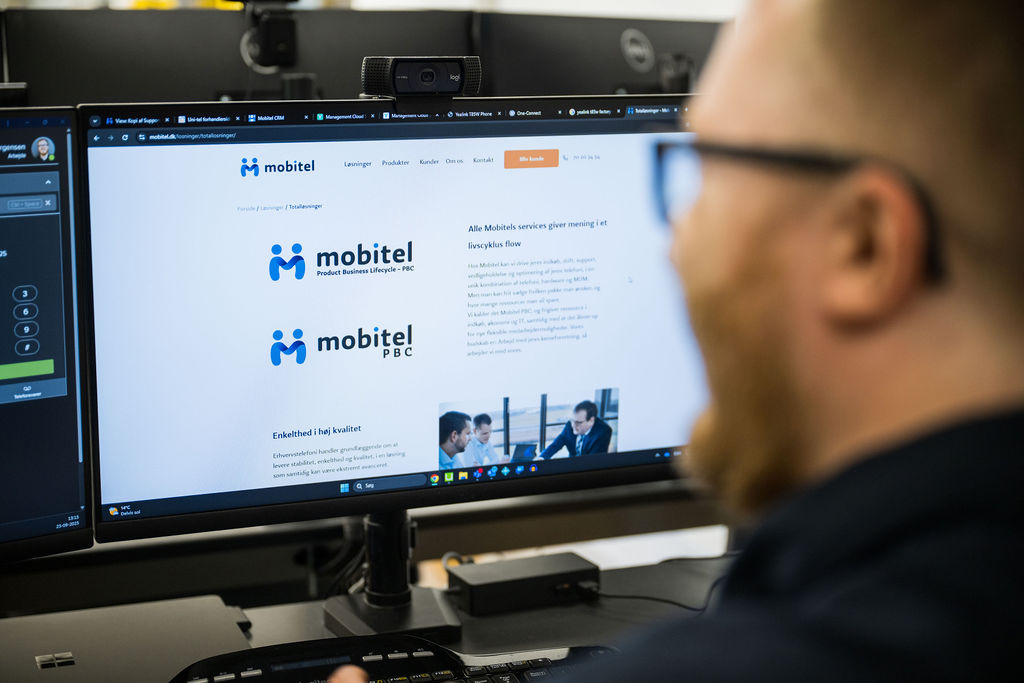 En medarbejder hos Mobitel arbejder ved en computerskærm, der viser virksomhedens løsninger inden for Product Business Lifecycle (PBC) og Life Cycle Management